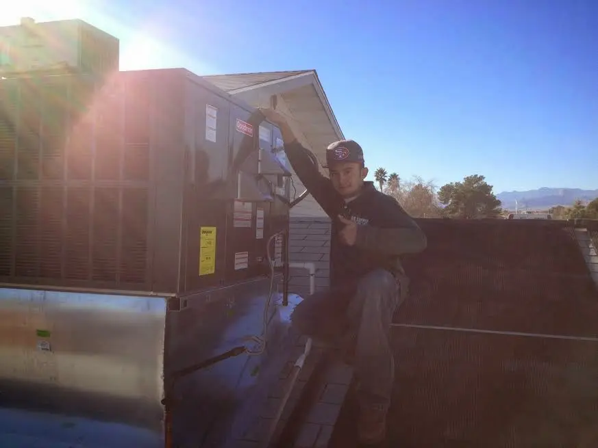 HVAC technician performing HVAC Inspection on a rooftop unit in Bethel